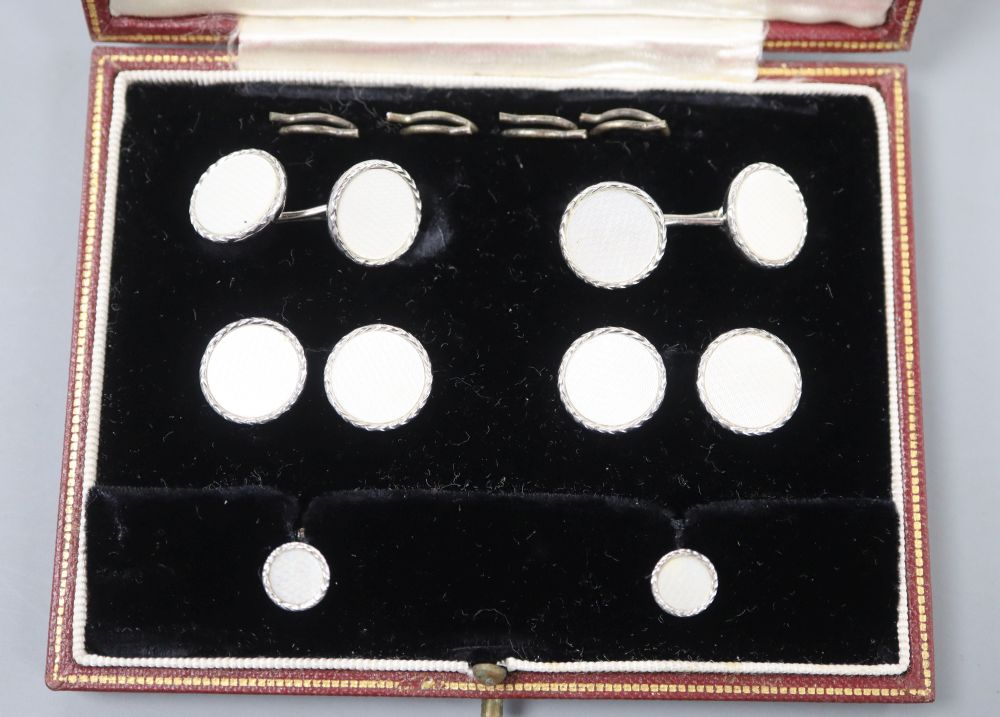 A cased 9ct white gold and mother-of-pearl eight piece dress stud set, in Garrard & Co box, gross 15.2 grams.
